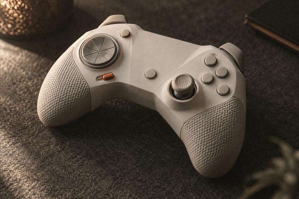 Close-up of an unbranded white game controller on a dark desk mat